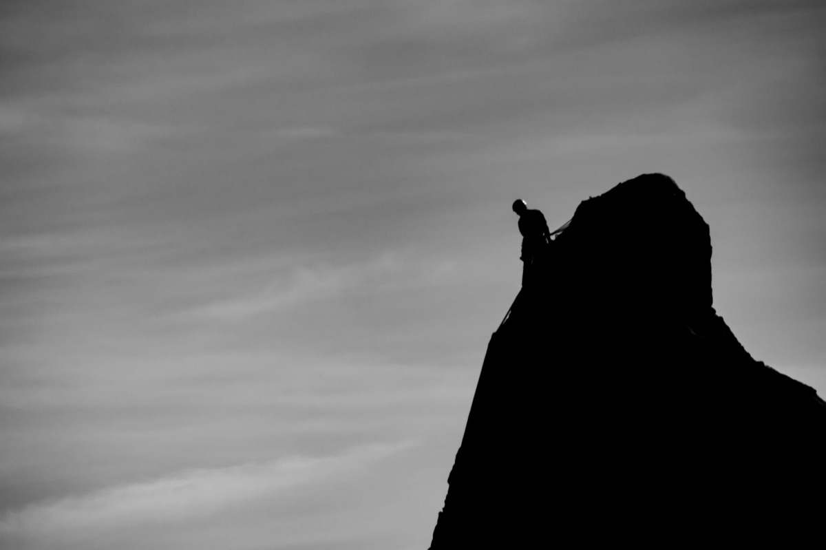 A person reaching the peak of a mountain symbolizing achievement and motivation