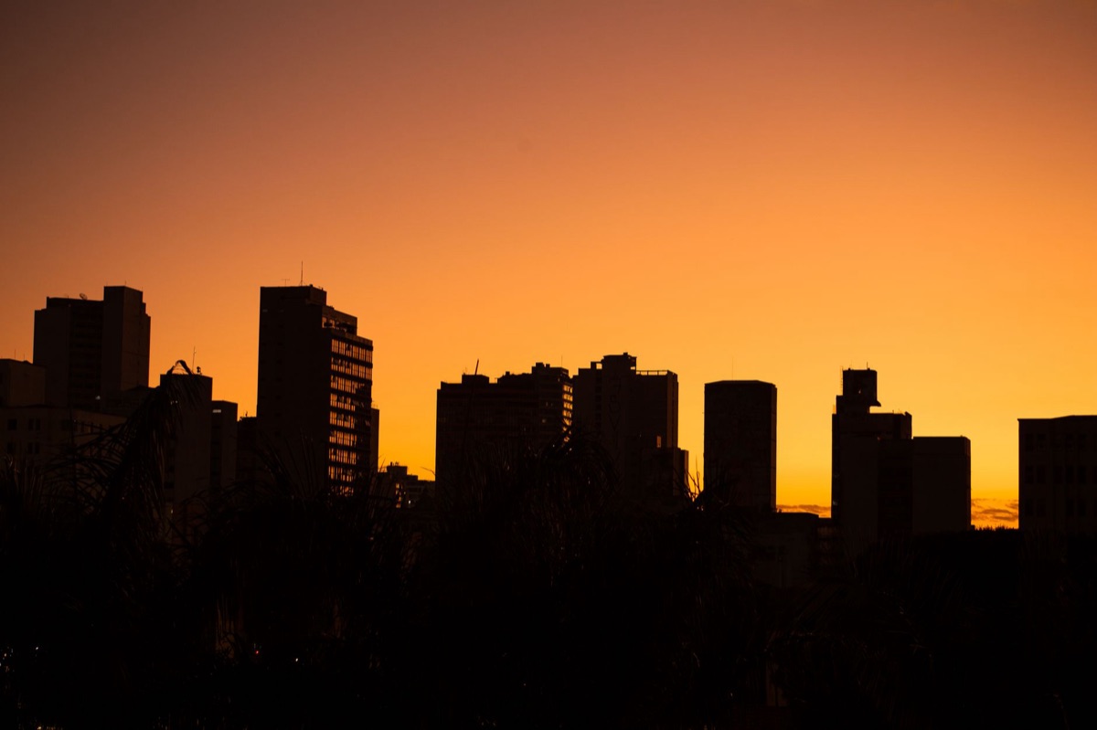 Vue aérienne d'un quartier d'affaires moderne au coucher du soleil, évoquant le succès professionnel.