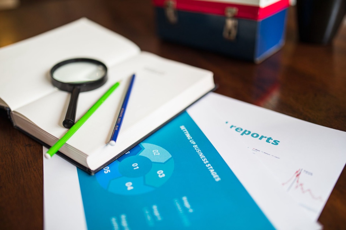 Une loupe examinant les détails d'un document, illustrant l'analyse des besoins clients.